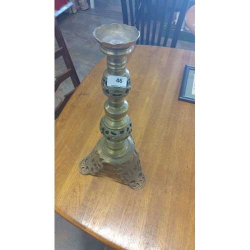 46 - Ornate brass candle holder with intricate cut-out design. This item features a tri-legged base and s... 