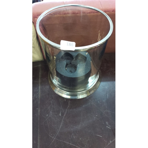 186 - Glass hurricane candle holder with a polished metal base. Comes with an internal candle with 3 wicks