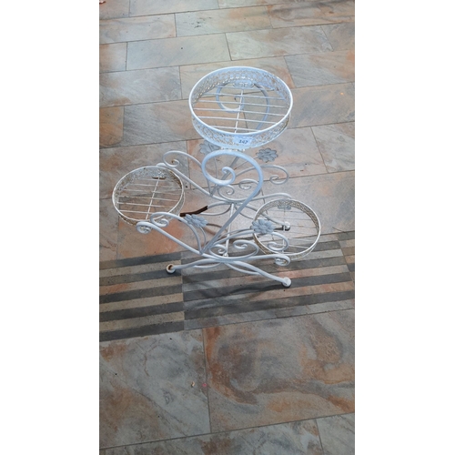 142 - Vintage wrought iron plant stand with three circular holders and decorative floral accents, painted ... 