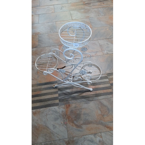 142 - Vintage wrought iron plant stand with three circular holders and decorative floral accents, painted ... 