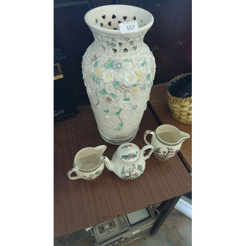 157 - Hand-painted floral ceramic vase with intricate cut-out design. Accompanied by three pieces of flora... 