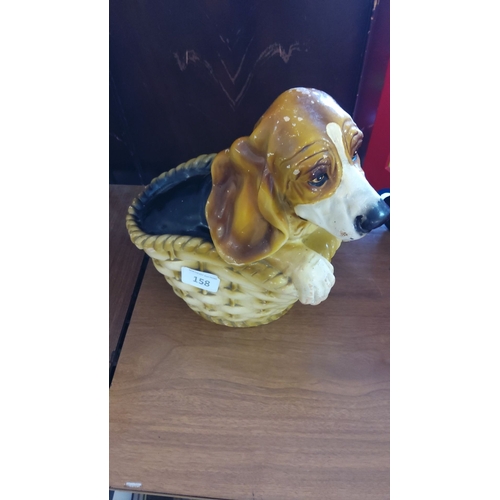 158 - Ceramic beagle dog peeking over a basket edge. Hand-painted in brown and white tones.