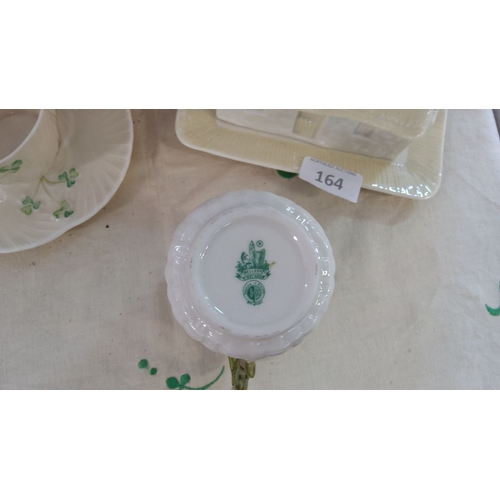 164 - Belleek porcelain set with a shamrock-decorated cup, saucer, mug, and thatched cottage butter dish. ... 