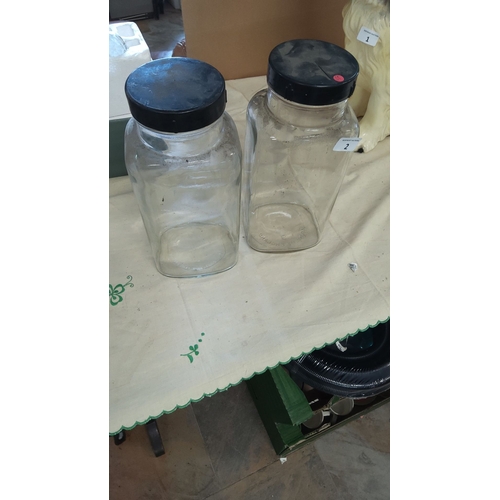 2 - Pair of clear sweetie storage jars with black lids, approximately 10 inches tall. Stamped 