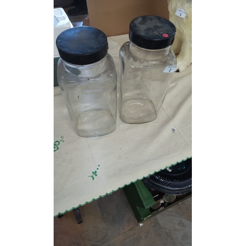 2 - Pair of clear sweetie storage jars with black lids, approximately 10 inches tall. Stamped 