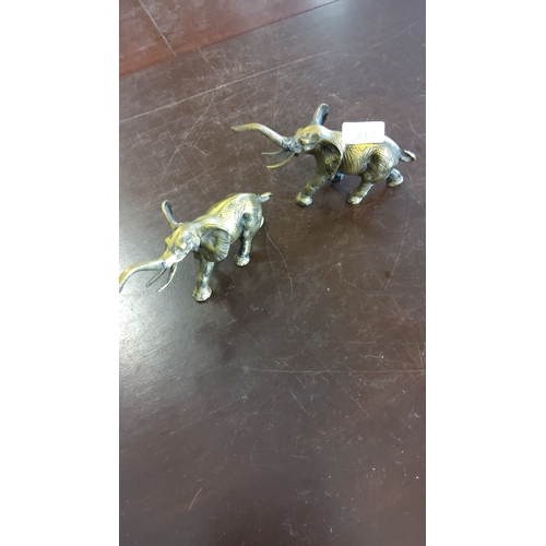 212 - Pair of brass elephant figurines with detailed engravings, each depicting an elephant with raised tr... 