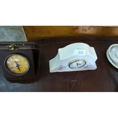 221 - Set of two vintage clocks. The first is encased in leather wrap with Roman numerals displayed. The s... 