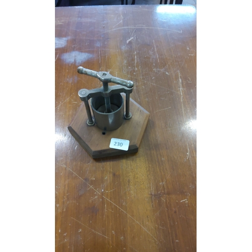 230 - Metal screw press with wooden base, hexagonal shape.