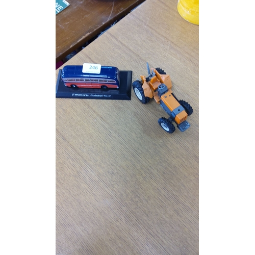 246 - Die-cast orange toy tractor and J T Whittle & Son Burlingham Seagull model bus on a stand.
