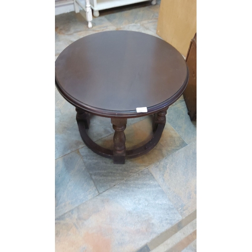 265 - Round wooden side table with turned legs and circular stretcher. Distinctive dark finish reflects mi... 
