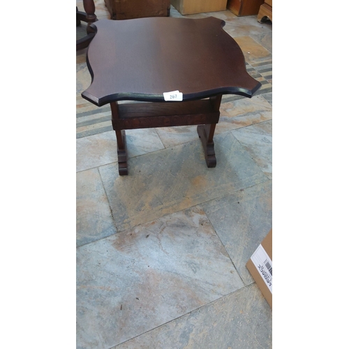 267 - Dark wood accent table with uniquely scalloped edges. The table features decorative carved details a... 