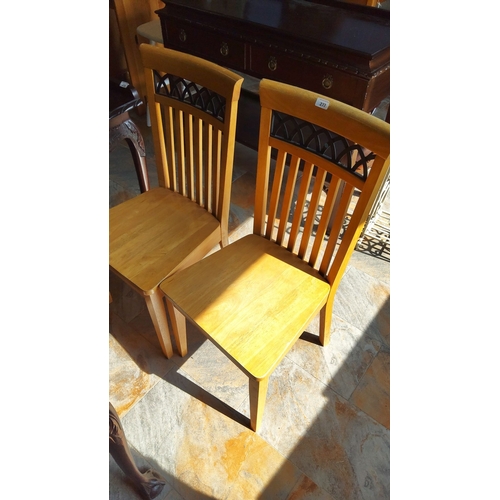 277 - Pair of wooden dining chairs with slatted backs and lattice detail. Natural wood finish.