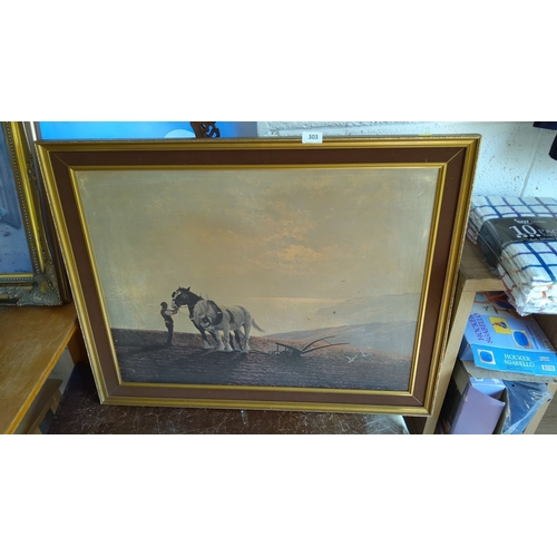 303 - Framed print depicting a farmer with two horses and a plow in a pastoral landscape. Framed with a go... 