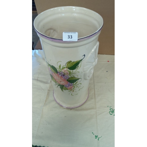 33 - Hand-painted floral ceramic vase with side handles. Cream base with pink, purple, and green floral m... 