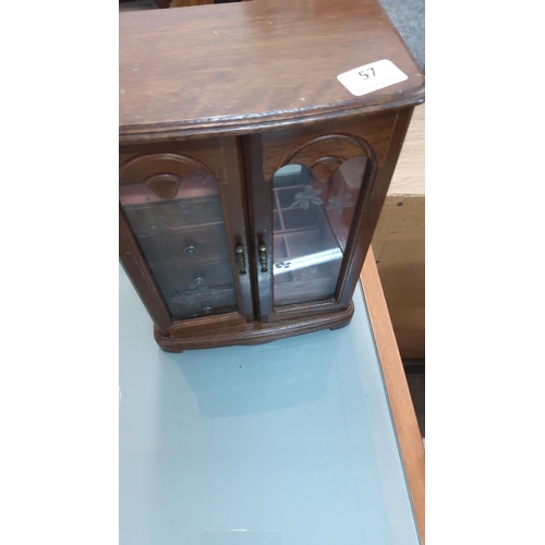 57 - Vintage wooden jewelry box with etched glass doors, multiple velvet-lined compartments, and three dr... 