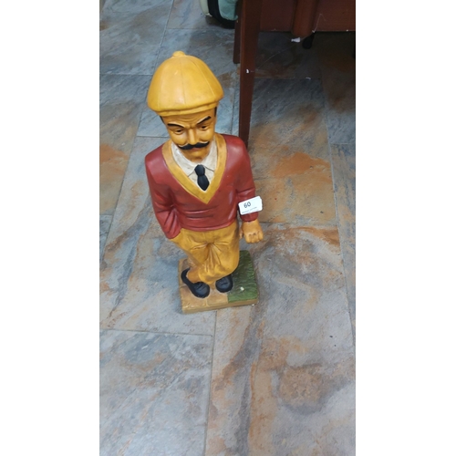 60 - Hand-painted figurine of a man, wearing yellow trousers, red sweater, and yellow cap, on a square ba... 