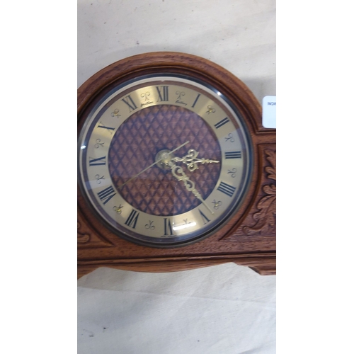 9 - Vintage wooden mantel clock featuring intricate carvings, Roman numeral dial, and brass-colored hand... 