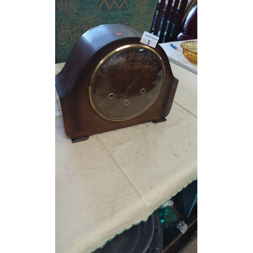 1 - Mantel clock with a classic wooden case, featuring brass accents and Roman numeral dial. From the ea... 