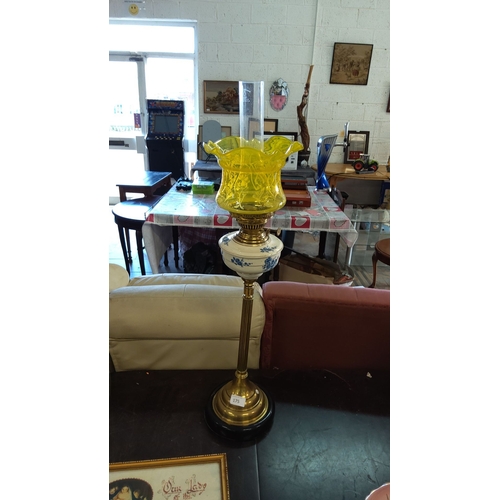 175 - Antique brass oil lamp with yellow etched glass shade and floral blue and white ceramic font, from t... 