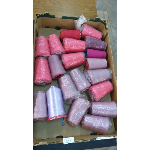 212 - Assorted lot of 20 spools of pink, purple, and lavender threads in a cardboard box.