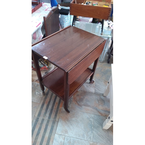 270 - Mid-Century Modern mahogany rolling bar cart with drop leaves and lower shelf. Features sleek design... 