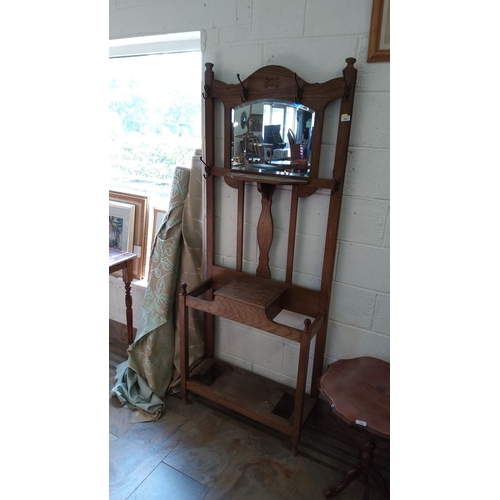 282 - Edwardian oak hall stand with central framed mirror, coat hooks, and umbrella/store compartment from... 