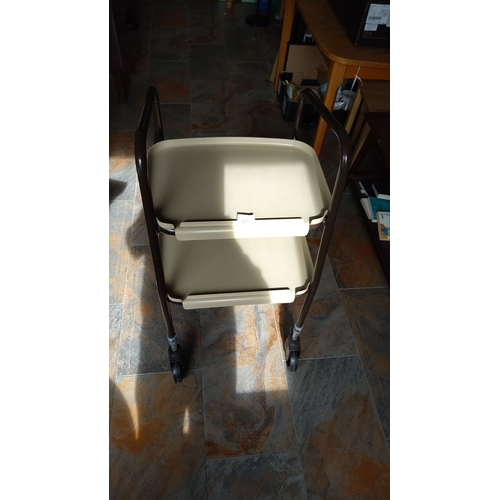 285 - Vintage rolling utility cart with a sturdy brown metal frame and beige plastic double-tiered trays.