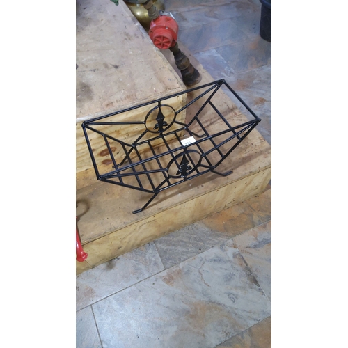 335 - Black wrought iron magazine rack with decorative fleur-de-lis accents.