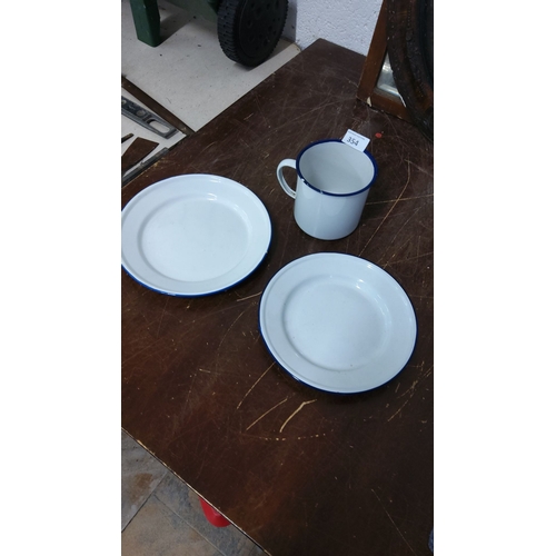 354 - Enamelware kitchen set includes two white plates with blue rims and one matching mug. Classic vintag... 