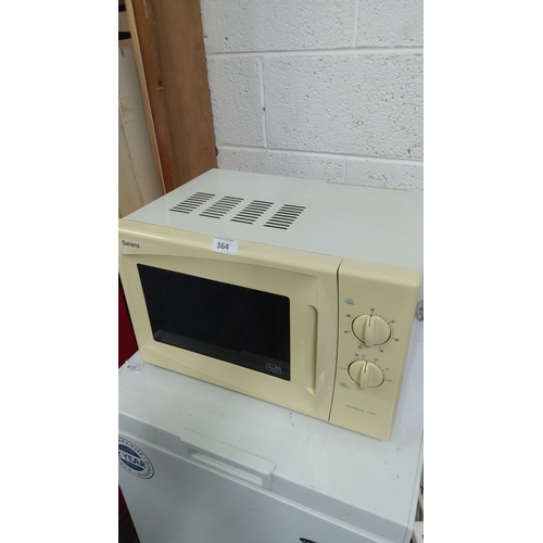 365 - Galanz microwave oven, beige, features dial controls for settings and timer. Compact countertop desi... 