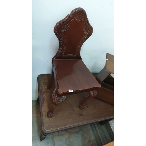 371 - Ornate mahogany hall chair with detailed carvings on the backrest and legs. Classic design.