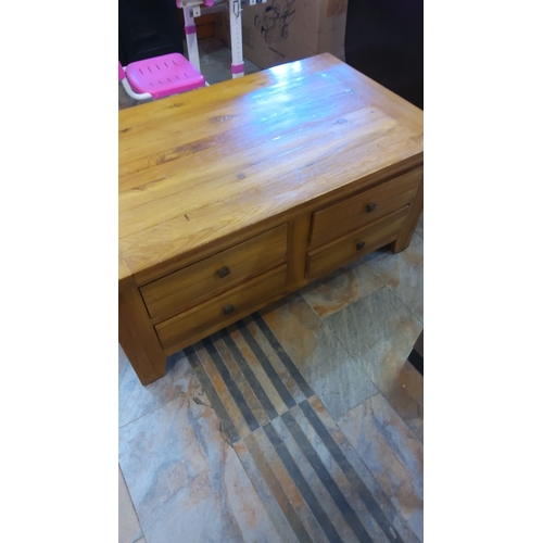 376 - Solid oak coffee table features four spacious drawers and showcases a natural wood grain with a stur... 