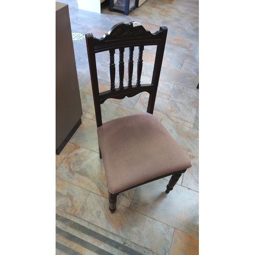 377 - Antique wooden chair featuring turned spindles and a carved backrest, upholstered in brown fabric.