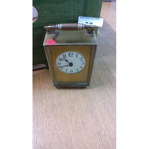 38 - Antique brass carriage clock, featuring a white dial with black numerals and an ornate handle from t... 