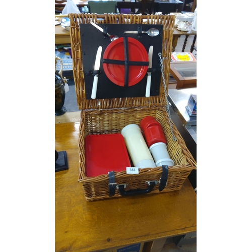 381 - Vintage wicker picnic hamper with red and white plastic utensils, plates, storage containers, and a ... 