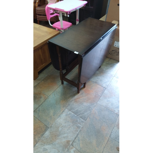 386 - Antique oak drop-leaf table with a dark finish, featuring turned legs and gateleg supports. From the... 