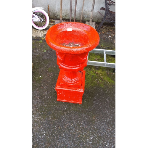 388 - Concrete garden urn, painted in vibrant red, featuring intricate design details and pedestal base.