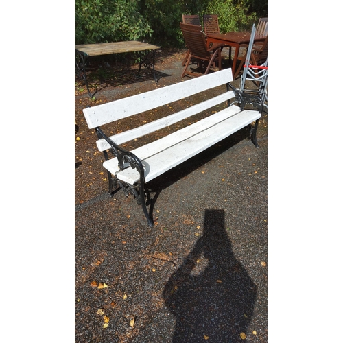 401 - White wooden outdoor park bench with ornate black cast iron sides. Classic design.