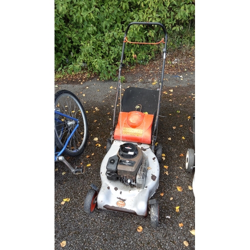 408 - Qualcast Classic Petrol Push Lawnmower features a Briggs & Stratton engine and a metal chassis.(unte... 