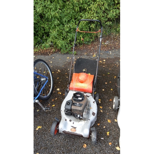 408 - Qualcast Classic Petrol Push Lawnmower features a Briggs & Stratton engine and a metal chassis.(unte... 