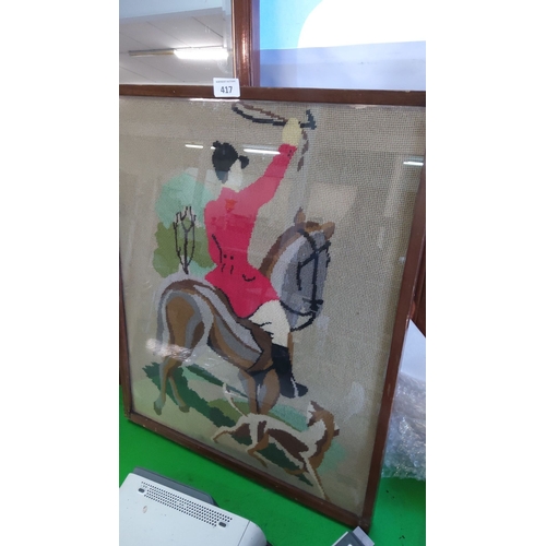 417 - Framed needlepoint of a hunt scene, featuring a rider in a red coat on horseback with hounds, housed... 