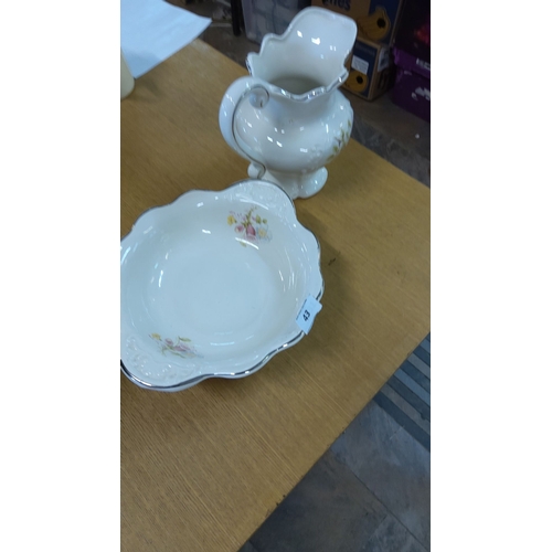 43 - Porcelain pitcher and basin set with floral design and silver trim.