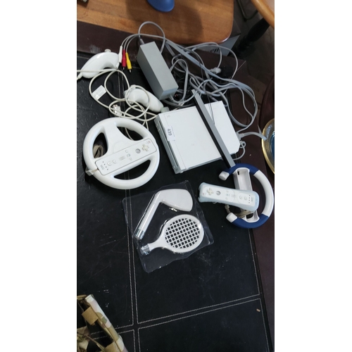 439 - Nintendo Wii console and accessories, including steering wheels, golf club, tennis racket, and vario... 