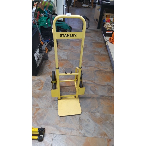 458 - Yellow Stanley hand truck with triple-wheel setup and durable steel frame.