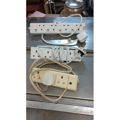 94 - Three power extension strips with multiple sockets and attached plugs.