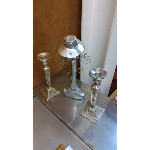 95 - Set of two vintage metal candlesticks, each with intricate detailing and ornate pedestal bases with ... 