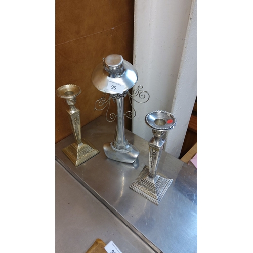 95 - Set of two vintage metal candlesticks, each with intricate detailing and ornate pedestal bases with ... 