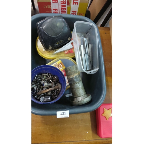 121 - Assorted hardware including bolts, nuts, staples, a cylindrical metal object, and a black office sta... 