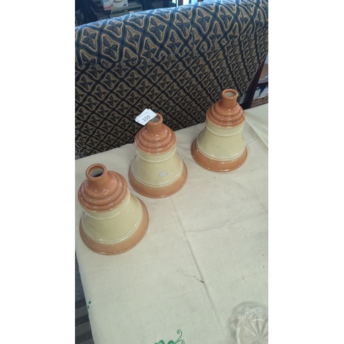 159 - Set of three vintage cream-toned pottery decanters with graduated bases and ridged detailing.