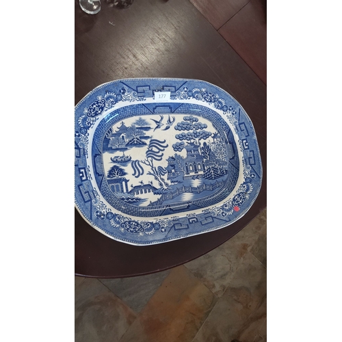 177 - Blue and white porcelain serving platter, featuring a traditional Willow Pattern design depicting a ... 